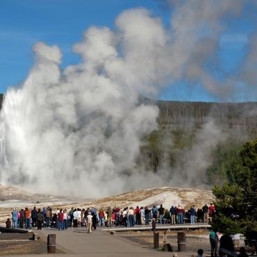 นักท่องเที่ยวกำลังชมน้ำพุร้อนโอลด์ เฟธฟุล ในอุทยานแห่งชาติเยลโลว์สโตน